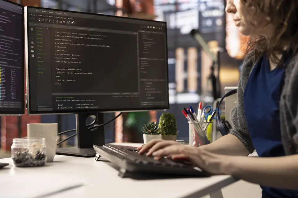Web developer writing code on a desktop monitor during website development